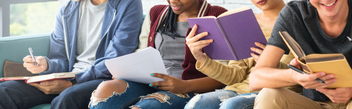 Teens sitting on a couch with books