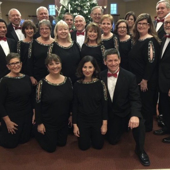 Group shot of the BG Singers choir dressed for a performance in suits and dresses